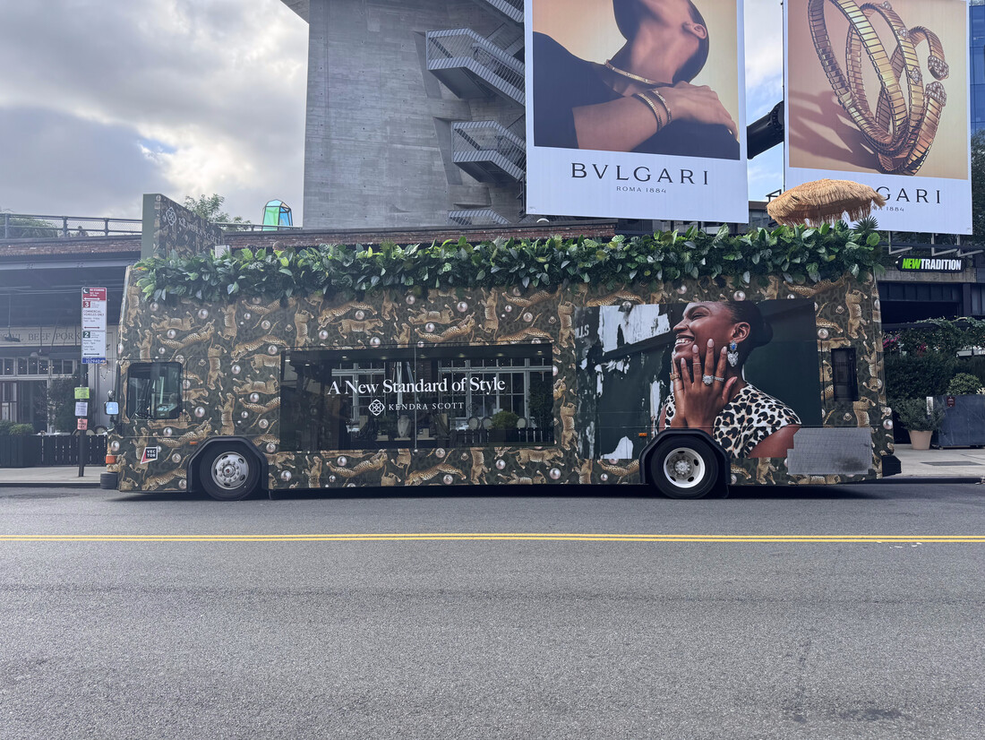 Custom-wrapped double-decker glass bus with a rooftop garden on a city street