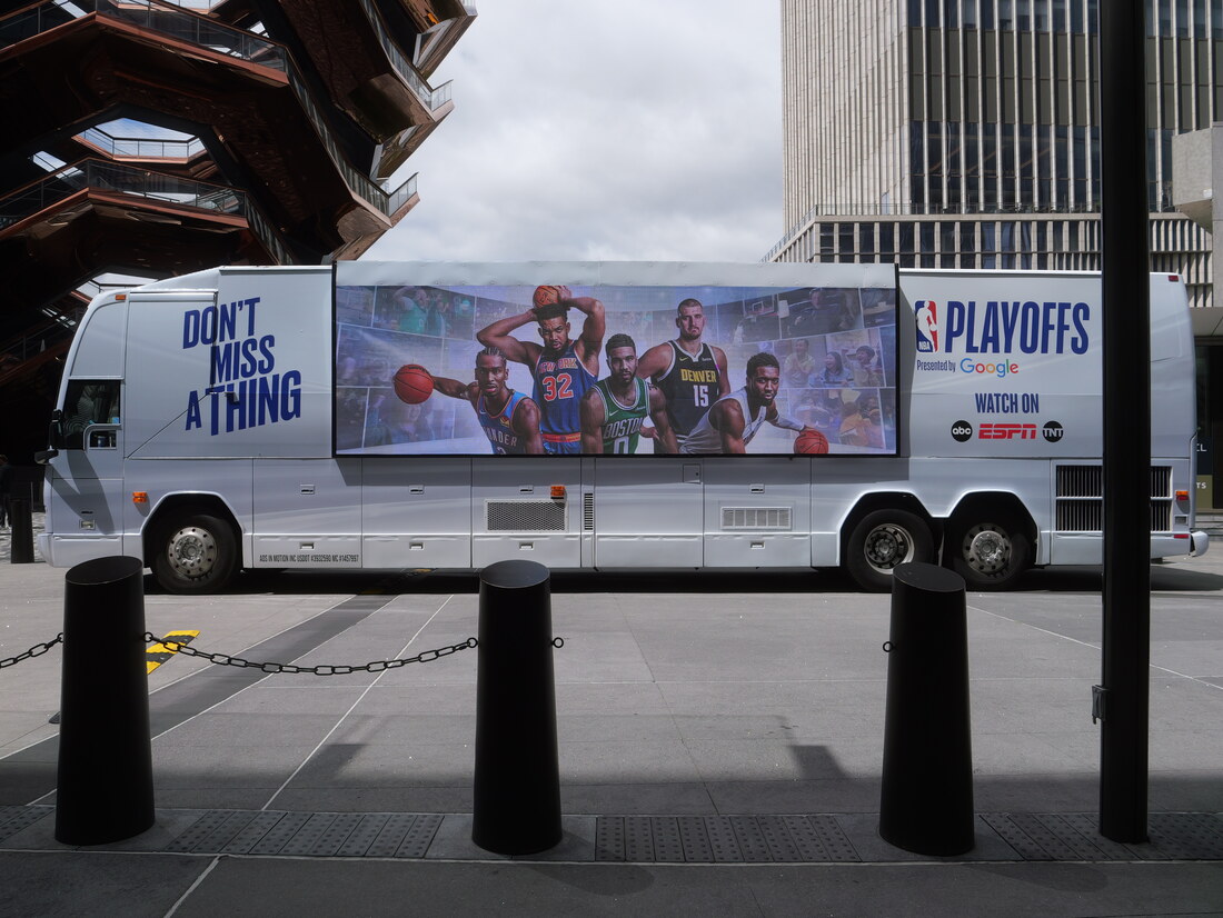 Bus with a large full-motion LED sports broadcast screen on its side
